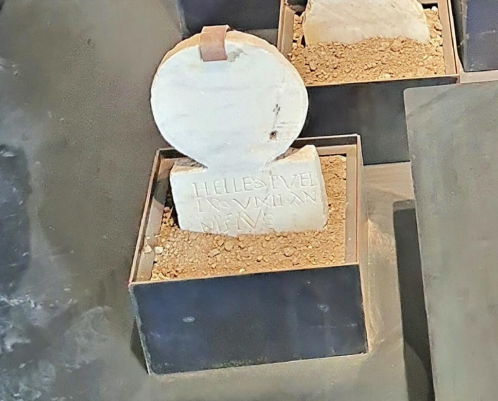 Pompeii Porta Nocera. Tomb 19aOS. Cippus of Helle Puella.
On display in exhibition “L’altra Pompei, vite comuni all’ombra del Vesuvio”.
Photo courtesy of Giuseppe Ciaramella.
A marble columella was found with the inscription -
HELLE PVEL
LA VIXIT AN
NIS IV.
This reads as 
Helle Puella vixit annis IV
The tomb name is unknown, and according to De Caro, it is unlikely to be that of the four-year-old slave Helle Puella.
See D’Ambrosio, A. and De Caro, S., 1983. Un Impegno per Pompei: Fotopiano e documentazione della Necropoli di Porta Nocera. Milano: Touring Club Italiano. (19aOS).