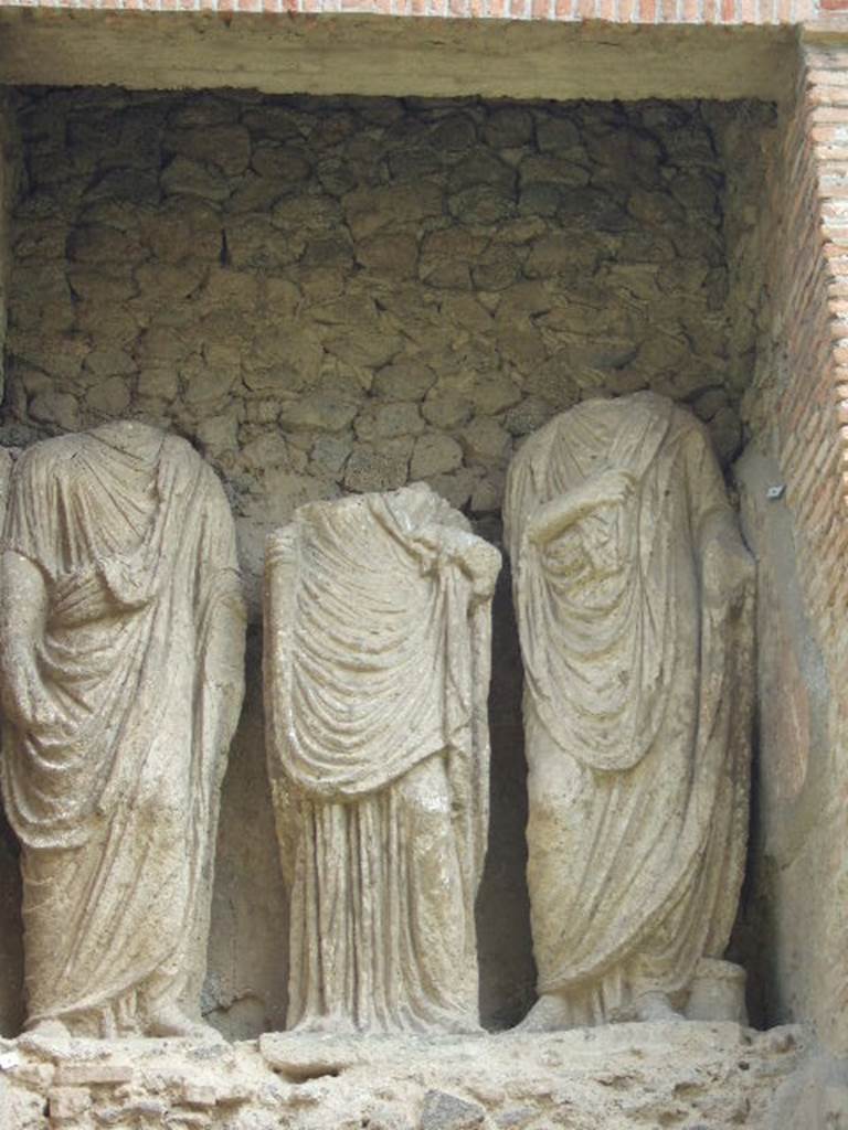 Pompeii Porta Nocera Tomb 23OS. Three headless statues. May 2006.
Publius Vesonius Phileros I, to the left wearing a toga. Vesonia, daughter of a Publius Vesonius, is in the centre wearing in tunic and mantle. Marcus Orfellius Faustus, to the right wearing a toga.