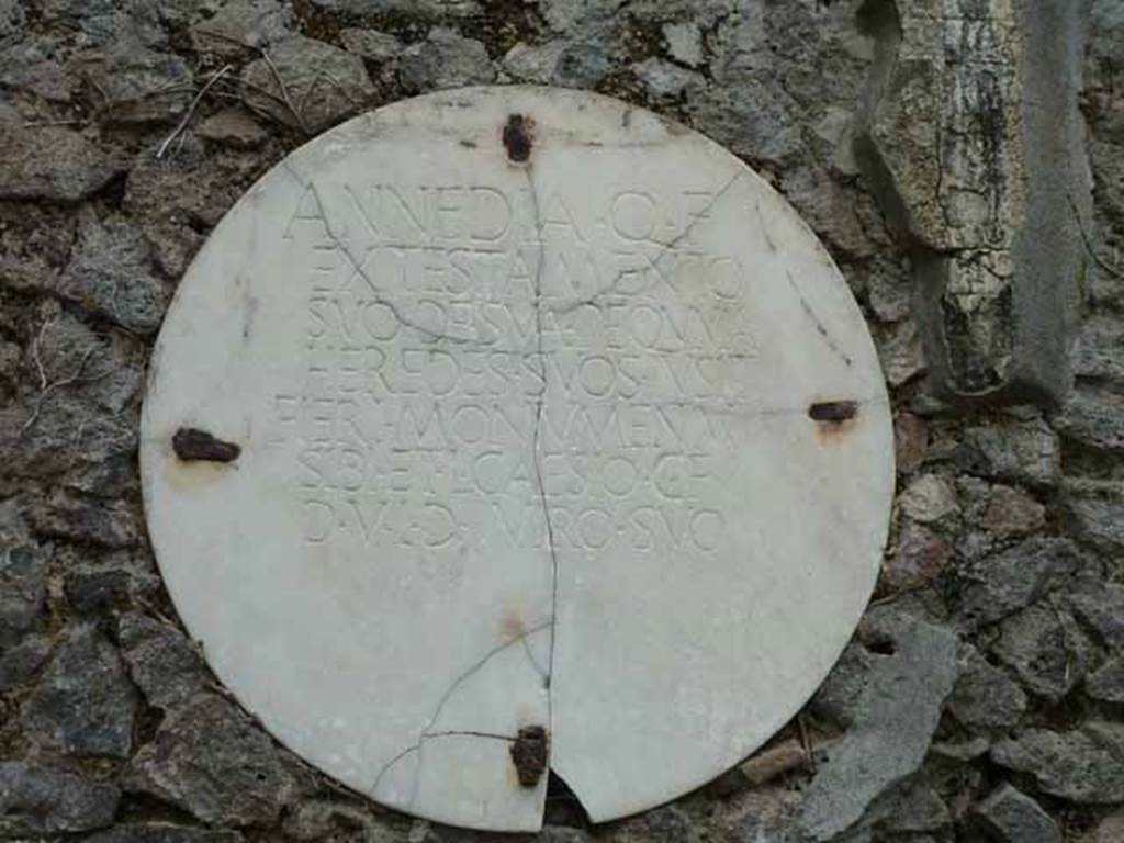 Pompeii Porta Nocera. Tomb 29OS. May 2010. Round marble plaque with inscription. 
ANNEDIA Q(uinti) F(ilia)
EX TESTAMENTO
SVO DE SVA PEQVNIA
HEREDES SVOS IV SIT
FIERI MONVMENTVM
SIBI ET L(ucio) CAESIO C(ai) F(ilio)
D(uo) V(iro) I(ure) D(icundo) VIRO SVO.