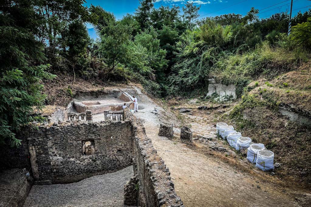 Porta Sarno la tomba di Marcus Venerius Secundio. August 2021. Looking south-east to new tomb opposite road area E. 
A hermetically sealed burial chamber can be seen at the front of the tomb. Tomb areas B and A are in the foreground. 
Guardando verso sud-est alla nuova tomba di fronte all'area stradale E. 
Un ambiente ermeticamente chiuso può essere visto nella parte anteriore della tomba. Le aree tombali B e A sono in primo piano.
Photograph © Parco Archeologico di Pompei.