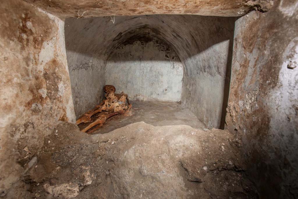 Porta Sarno la tomba di Marcus Venerius Secundio. August 2021. Mummified skeleton in hermetically sealed inner chamber.
No less exceptional than the inscription is the burial of Marcus Venerius Secundio, with one of the best-preserved skeletons ever found in the ancient city. 
The deceased was buried in a small cell of 1.6 x 2.4 metres, located behind the main façade
Scheletro mummificato in un ambiente ermeticamente chiuso.
Non meno eccezionale dell'iscrizione risulta la sepoltura di Marco Venerio Secundio. 
Si tratta di uno degli scheletri meglio conservati ritrovati nella città antica. 
Il defunto fu inumato in una piccola cella di 1,6 x 2,4 metri posta alle spalle della facciata principale.
Photograph © Parco Archeologico di Pompei.