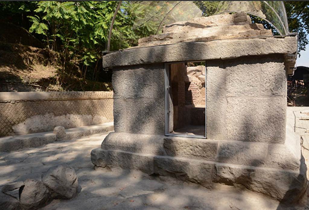 SG5 Pompeii. 2018. Entrance to tomb on side facing south away from the Stabian Gate.
The entrance to the tomb is closed by a limestone door, which features two legible tituli picti. 
The door has an iron ring on the outside, and a bronze locking system on the inside, as well as bronze hinges. 
The door was closed at the time of the excavation, and was opened for the 2017 restoration works, revealing that it still worked perfectly, 2000 years since the Roman locking mechanism was crafted. 
On the upper part of the door an inscription is present, in the form of a titulus pictus, which reports “Iarinus Expectato / ambaliter unique sal(utem) / Habito sal(utem)” “Iarinus greets Expectatus as an eternal friend; greetings to Habitus”. Above the name of Habitus, somebody drew a phallus.
See http://pompeiisites.org/en/comunicati/the-tombs-of-the-necropolis-of-porta-stabia/