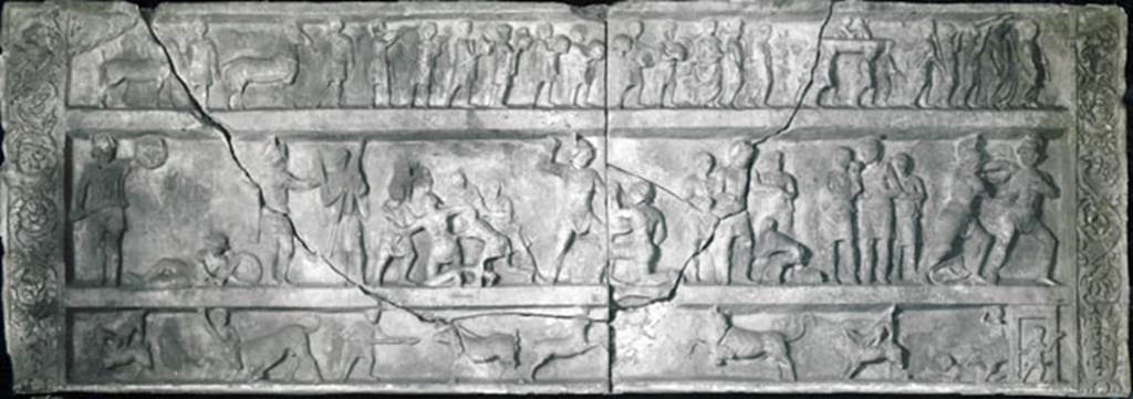 SG7 Pompeii. Gladiatorial relief from tomb at Porta Stabia. 
Now in Naples archaeological Museum. Inventory number 6704.
According to Emmerson, this relief measures more than 4 metres long and 1.5 metres high.
See Emmerson A., 2010. Reconstructing the Funerary Landscape at Pompeii's Porta Stabia: Rivista di Studi Pompeiani 21, p. 78, fig. 1.
This has now been suggested it may be part of the tomb at Porta Stabia with the 4 metre long inscription newly discovered in 2017.
That tomb has been suggested to be that of Gnaeus Alleius Nigidius Maius, prolific provider of gladiatorial games and beast hunts in the amphitheatre, like those shown in the relief. 
See tomb SG6.