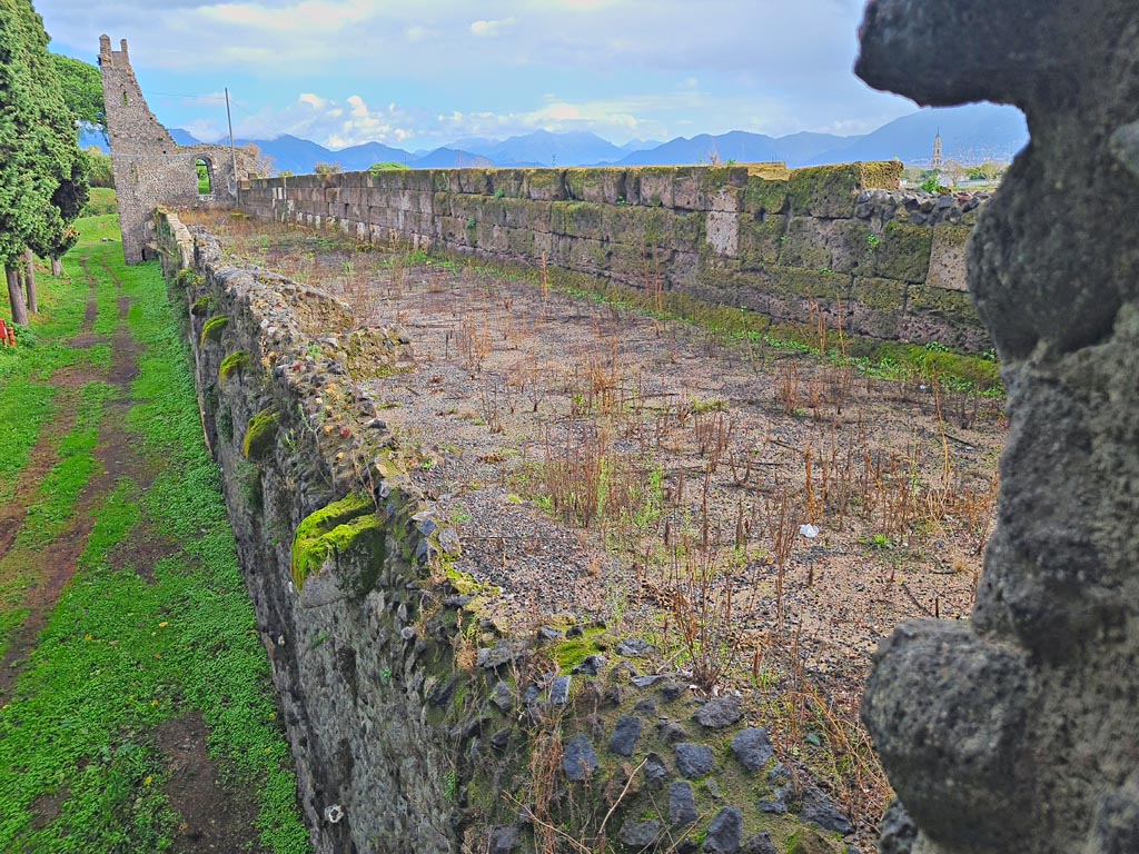 Tower XI, Pompeii. November 2023. 
Looking east through window in north-east corner of middle floor room, along walls towards Tower X. Photo courtesy of Giuseppe Ciaramella.