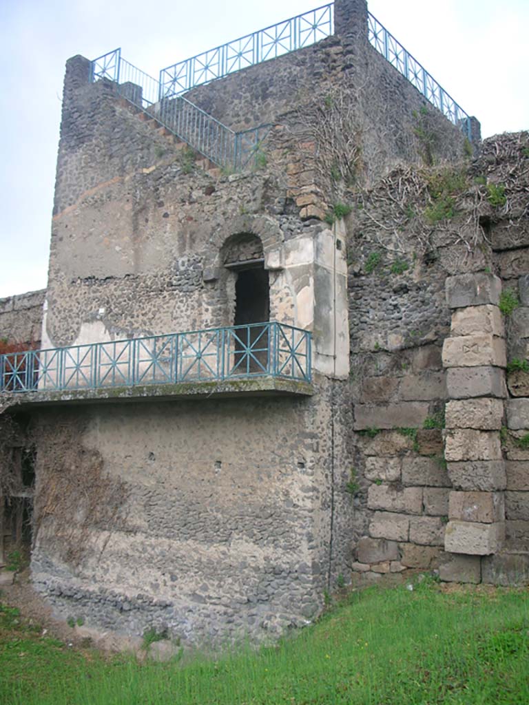 Tower XI, Pompeii. May 2010. 
Looking north-west across south side of Tower. Photo courtesy of Ivo van der Graaff.
On page 74 of his book, Van der Graaff points out the differences in the towers and divides them into four types –
“Group One. This includes Towers X, XI and XII.
They feature an entrance on the rear right side of the building opening up on two sets of stairs: one heads straight down to the first floor, the other ascends to the second floor on the left. This setup allows for the presence of arrow slits at the corner of the staircases. The first floor is a wide-open barrel vaulted chamber. A door in the back opens on a rear corridor heading to the postern placed on the right side of the building. On the second floor, two doors opened onto the wall-walk, whereas another staircase in the back gave access to the top third floor.”
See Van der Graaff, I. (2018). The Fortifications of Pompeii and Ancient Italy. Routledge, (p.74).
