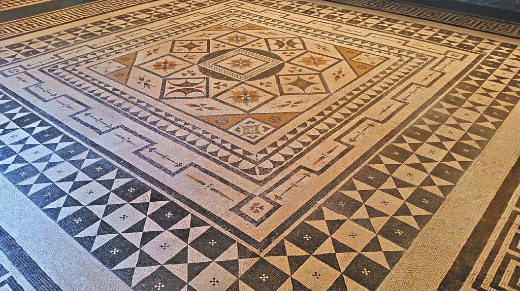 Villa Urbana, Varano, Stabiae or VIII.2.1 Pompeii. July 2019.  
Beautiful central emblema of coloured mosaic set into floor in Naples Archaeological Museum, “Magna Grecia” collection. 
Photo courtesy of Giuseppe Ciaramella.
It is thought this central emblema may be from one of these two houses, now seen re-set into another mosaic floor.
Many artists in the 19th century have seen and drawn this mosaic in Naples Museum.
According to Abbate, this mosaic was from either Stabia or Pompeii.
According to Zanella –
This mosaic, shown on page 107, fig.49, a drawing by L. Destouches, 1816-1817; (collection Pierre Pinon); is described as being from Casa di Championnet, VIII.2.1 in Pompeii.
See Zanella S., 2019. La caccia fu buona: Pour une histoire des fouilles à Pompéi de Titus à l’Europe. Naples : Centre Jean Bérard, (P.107).
According to Real Museo Borbonico, vol.15, Tav 24 (XXIV), this mosaic is from the Villa of Tiberius on Capri. 
According to Pisapia, this mosaic is from Stabia, Villa Urbana.
See Pisapia, M. S. 1989, in Mosaici antichi in Italia, Regione prima. Stabia, Roma, (p.67-70, no.124).