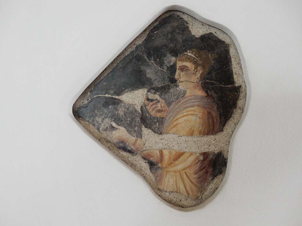 Villa della Pisanella, Boscoreale. May 2018. Upper floor. Black ground fresco with a female figure feeding two apples to a child or animal. 
Photo courtesy of Buzz Ferebee.