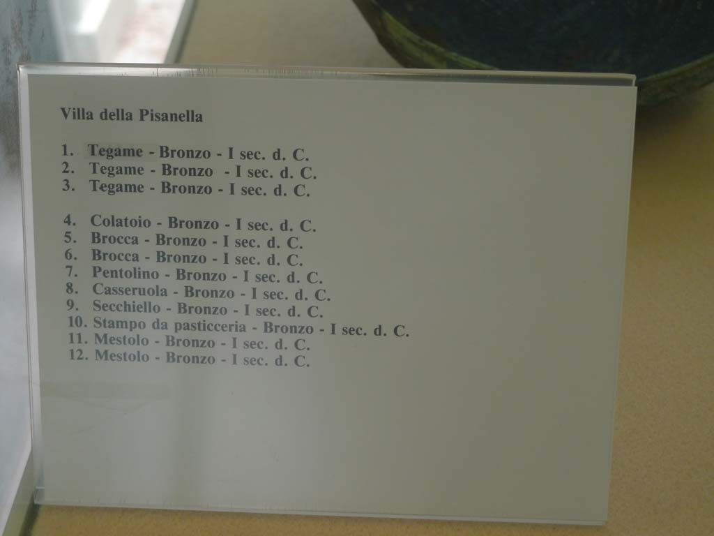 Villa della Pisanella, Boscoreale. July 2010. Information card from Boscoreale Antiquarium giving detail of 12 bronze items found in the villa. 
Photo courtesy of Michael Binns.