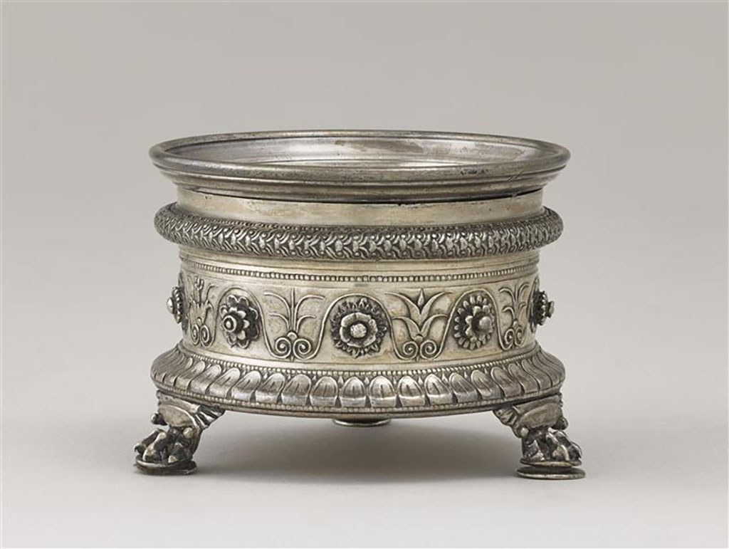 Villa della Pisanella, Boscoreale. Boscoreale Silver. Miniature tripod with zoomorphic foot supporting a salt cellar. 
Guilloche decoration, tongues and friezes of palmettes and flowers. Owners name engraved in Latin: Pamphilus, imperial freedman.
Trépied miniature avec pied zoomorphe supportant une salière. Salière : décor de guillochis, languettes et frise de palmettes et de fleurs. 
Nom propre gravé en latin : Pamphilus, affranchi impérial.
Now in the Louvre, inventory number BJ2000.
Photo © RMN-Grand Palais (musée du Louvre) / Stéphane Maréchalle.