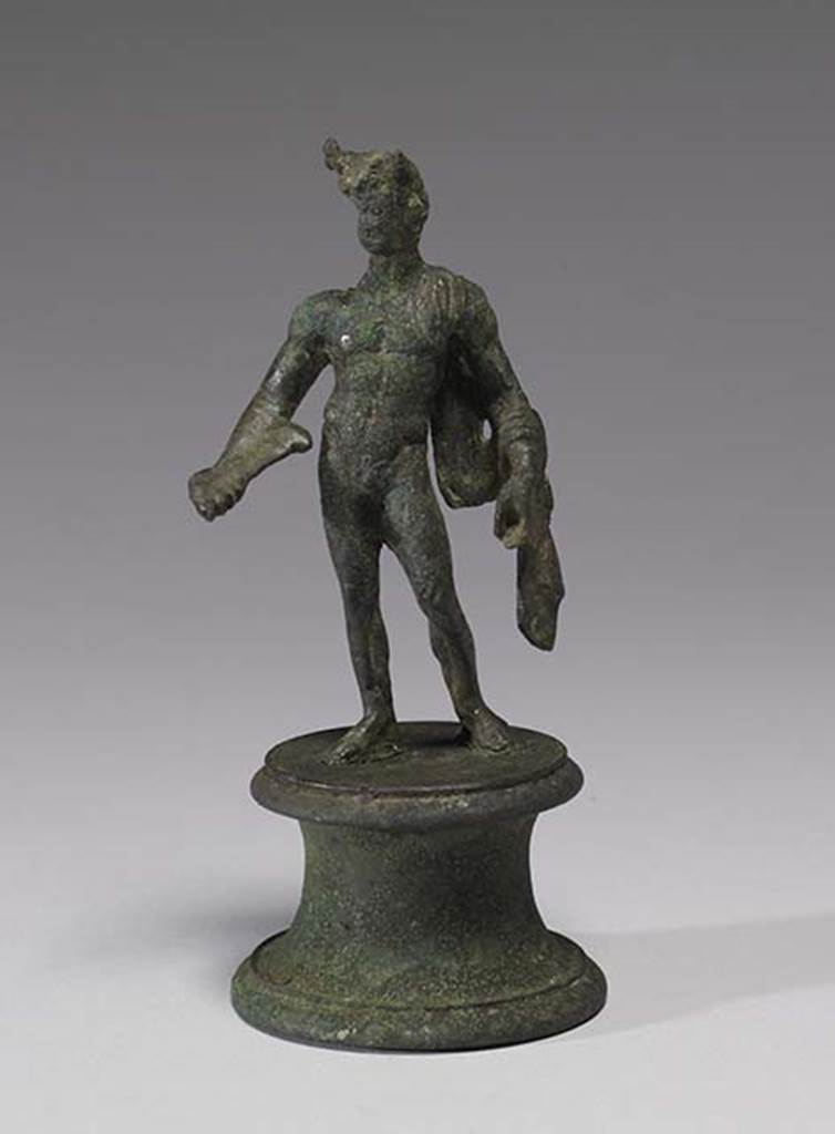 Boscoreale, Villa rustica in fondo D’Acunzo. Room 12, lararium. 
According the The Walters Art Museum, this is a bronze statuette of Mercury, front view.
According to Della Corte, this statuette seemed to represent a faun, (0.12 high) naked except for a goat skin between the left shoulder and corresponding elbow.
He has what may be a syrinx? (pan-pipe) held lowered in his right hand. 
Upon his head were two projections on the sides of the forehead, apparently horns, but they were seriously damaged. 
See Notizie degli Scavi di Antichità, 1921, p. 441. According to Stefani, the different. and more plausible interpretation proposed by others is an image of Mercury.
See Stefani G., 2000. In Sylva Mala, Bollettino del Centro Studi Archeologici di Boscoreale, Boscotrecase e Trecase XII, p. 11-16 and note 44.
Photo courtesy of The Walters Art Museum, Baltimore. Inventory number 54.748.
http://thewalters.org/
Creative Commons Attribution-ShareAlike 3.0 Unported Licence