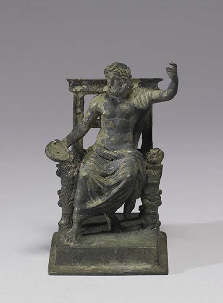 Boscoreale, Villa rustica in fondo D’Acunzo. Room 12, lararium. 
Bronze statuette of seated Jupiter, front view.
According to Della Corte, the statue, (0.09 high including the square base) represented Jupiter.
He is bearded, nude, except for the cloak over his left shoulder and around his legs, and is seated upon a throne;
In his right hand he held a patera, the left is raised as if resting upon a high sceptre, now missing.
See Notizie degli Scavi di Antichità, 1921, p. 440.
Photo courtesy of The Walters Art Museum, Baltimore. Inventory number 54.750.
http://thewalters.org/
Creative Commons Attribution-ShareAlike 3.0 Unported Licence