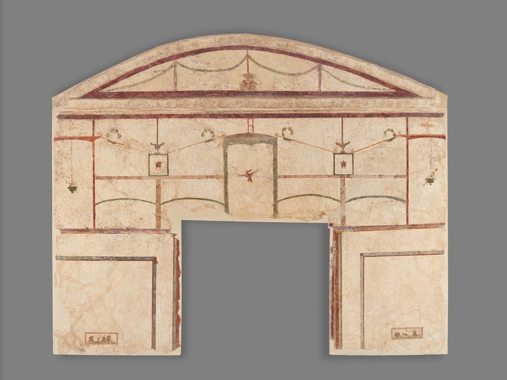 Boscoreale. Villa of Numerius Popidius Florus. Room 13. Frescoed Wall with Double White Field and a Niche.
Digital image courtesy of the Getty's Open Content Program. Now in the Getty Museum, inventory number 70.AG.89.
One of two frescoes that decorated the vaulted cubiculum (bedroom) of the Villa of Numerius Popidius Florus at Boscoreale (see also 70.AG.90). Adjacent to the villa’s bath, this was one of the last rooms to be decorated. The chamber (known as Cubiculum 13) contained frescoes with elegant compositions on a white background. This section of wall includes the upper part of a doorway. Portions of the original stucco ceiling mouldings, ornamented with impressed floral motifs, are still attached along the edge of the arch. The decoration of the upper register features columns and trellises that frame hanging garlands, birds, vessels, and theatre masks. On either side of the doorway, two groupings of satirical masks accompany a silver kantharos at left and a partially open basket at right. The painting style, categorized by scholars as Fourth Style, is the last style of Roman wall painting, and combines elements of the three styles that came before.
