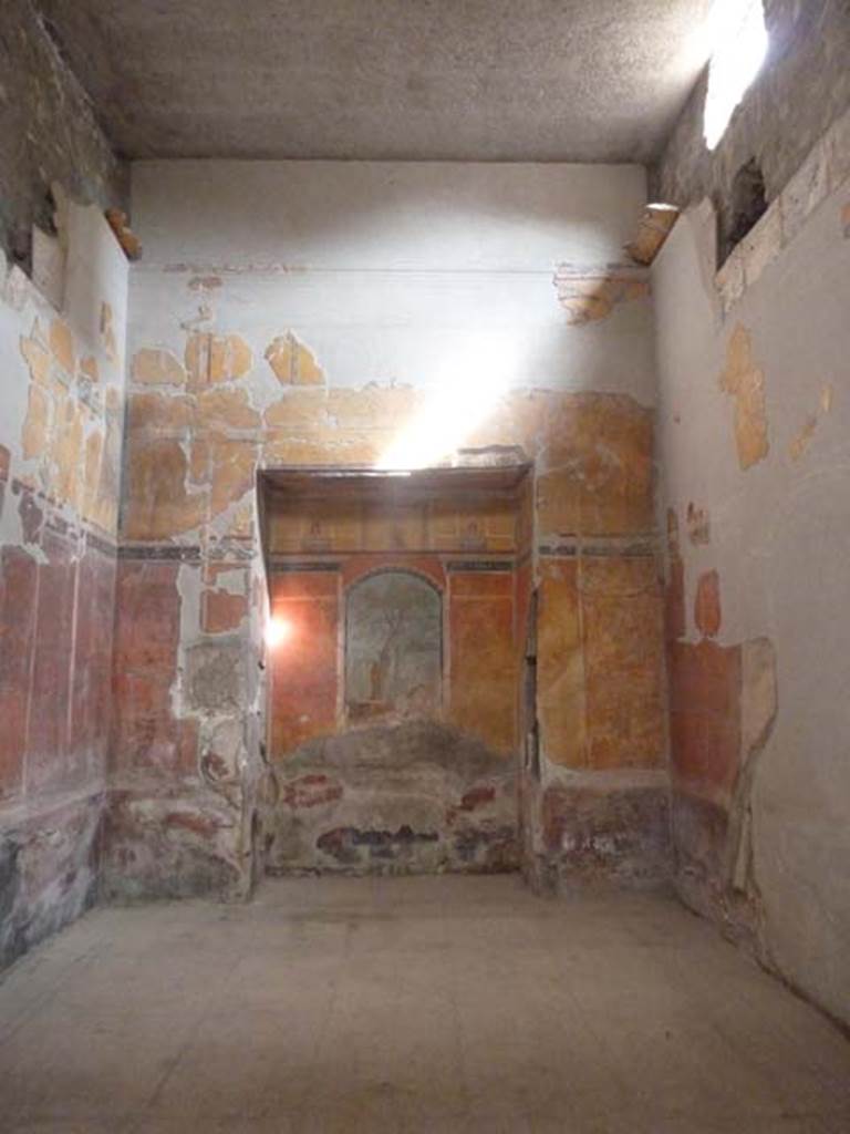 Oplontis Villa of Poppea, September 2015. Room 8, east wall with recess.  
Secondo a Carlo Malandrino - (insieme agli ambienti 18 and 31 formava il complesso termale della casa). 
Ha il pavimento con sospensurae e le pareti concamerate per il passaggio dell’aria calda proveniente dalla vicina cucina.
Le pareti sono dipinte in III stile. Nella nicchia di fondo, il quadro rappresenta Ercole nerl giardino delle Esperidi. 
Al disopra del quadro e sul succielo del rincasso sono dipinte delle preziose miniature paesaggistiche e mitologiche.
See Malandrino, Carlo, 1978. “Oplontis”, (p.71-2, vedi 16,17 e 18)
(translation: Together with rooms 18 and 31 these formed the thermal (baths)complex of the House).  
With suspended floor and walls recessed for the passage of warm air coming from the nearby kitchen. 
The walls are painted in III style. In the rear niche Hercules is represented in the garden of the Hesperides. 
Above the picture and on the ceiling recess, precious miniatures of landscapes and mythological subjects are painted..
See Malandrino, Carlo, 1978. “Oplontis” (p.71-2, see rooms 16, 17 and 18 on his plan)