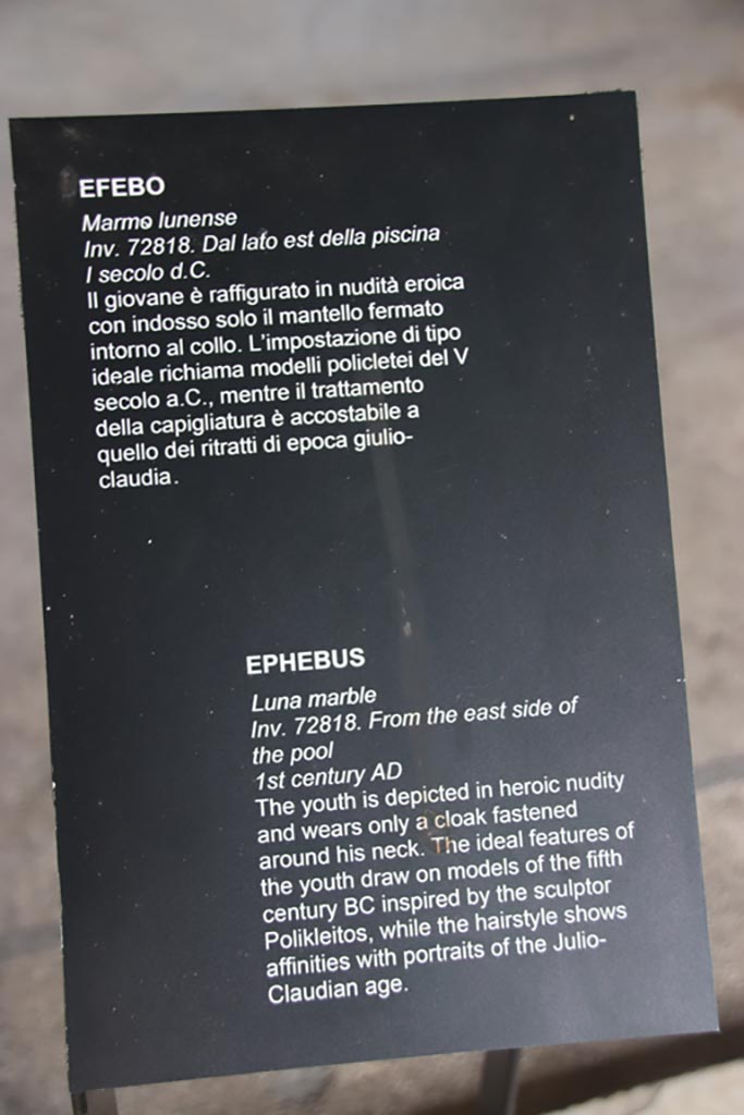 Villa of Poppaea, Oplontis, October 2023.
Room 65, description card for marble statue of Ephebus on display here, inv. 72818. 
Photo courtesy of Klaus Heese.