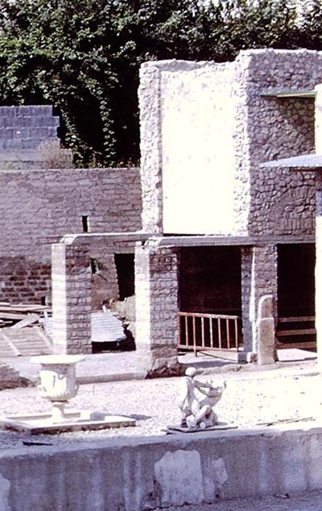 Oplontis Villa of Poppea, 1978. Room 84 is behind the pillars, at the east end of area 91, at the south end of the swimming pool 95. 
Detail from photo by Stanley A. Jashemski.   
Source: The Wilhelmina and Stanley A. Jashemski archive in the University of Maryland Library, Special Collections (See collection page) and made available under the Creative Commons Attribution-Non Commercial License v.4. See Licence and use details.
J78f0045