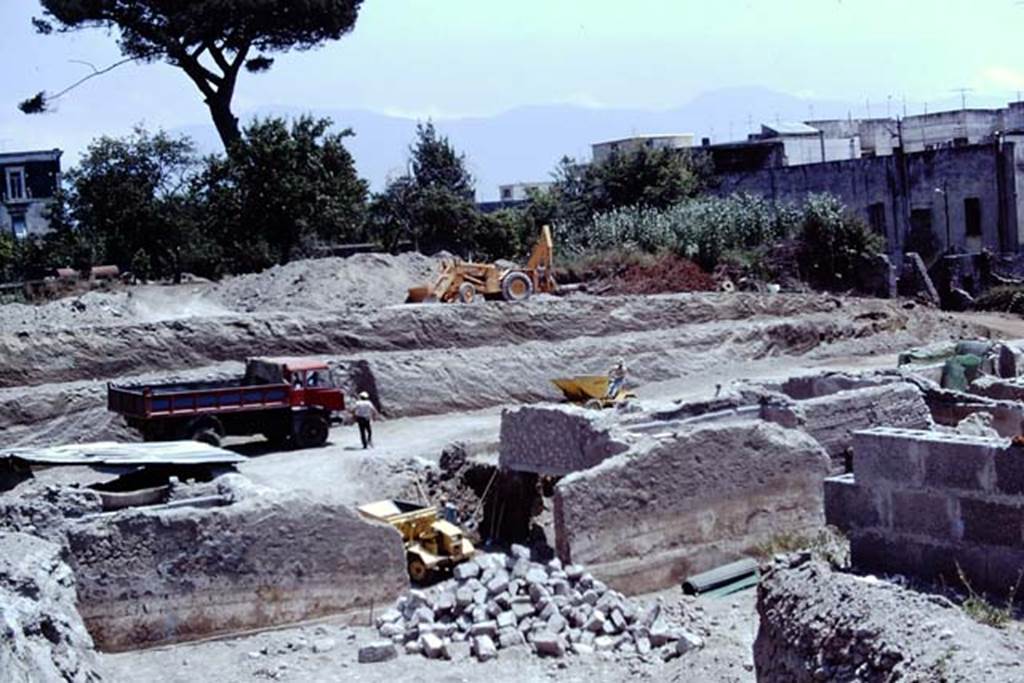 Oplontis Villa of Poppea, 1975 or 1974. Looking south-east across area of north garden towards room 69, (with yellow truck in it), which had a window onto the north garden in the wall this side, and opened on the far side onto the pool area 60. Photo by Stanley A. Jashemski.   
Source: The Wilhelmina and Stanley A. Jashemski archive in the University of Maryland Library, Special Collections (See collection page) and made available under the Creative Commons Attribution-Non Commercial License v.4. See Licence and use details. J74f0871