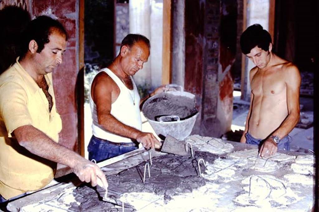 Oplontis Villa of Poppea, 1975 or 1974. Concentration, while applying the cement to the rear of the fallen fragments. Photo by Stanley A. Jashemski.   
Source: The Wilhelmina and Stanley A. Jashemski archive in the University of Maryland Library, Special Collections (See collection page) and made available under the Creative Commons Attribution-Non Commercial License v.4. See Licence and use details. J74f0888