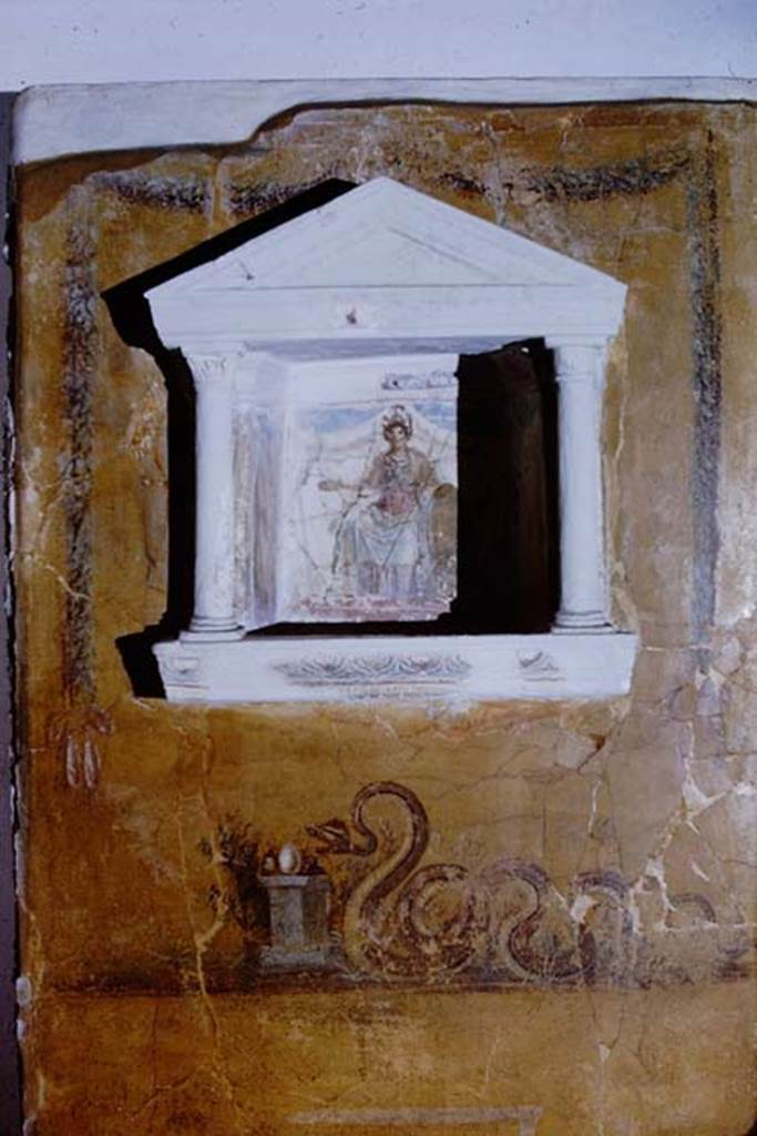Gragnano, Villa rustica in Località Carmiano, Villa A. 1968. 
From dividing pilaster between kitchen room 4 and room 2. 
Lararium in stucco found inserted in a yellow painted wall.
Photo by Stanley A. Jashemski.
Source: The Wilhelmina and Stanley A. Jashemski archive in the University of Maryland Library, Special Collections (See collection page) and made available under the Creative Commons Attribution-Non Commercial License v.4. See Licence and use details.
J68f1875
