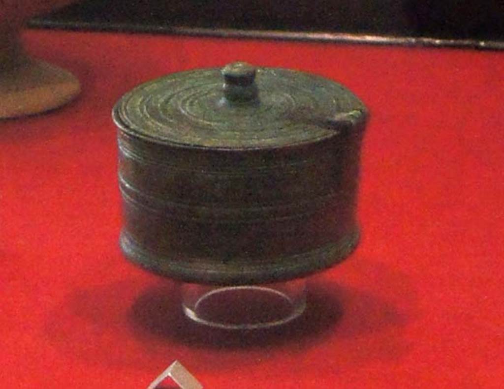 Gragnano, Villa rustica in Località Carmiano, Villa A. Room 9. 
Cylindrical bronze pyx (small round lidded box) with hinged lid and decorated with incised parallel lines. 
Stabiae Antiquarium, inventory number 63528.
Detail from photo courtesy of Margaret Hicks.