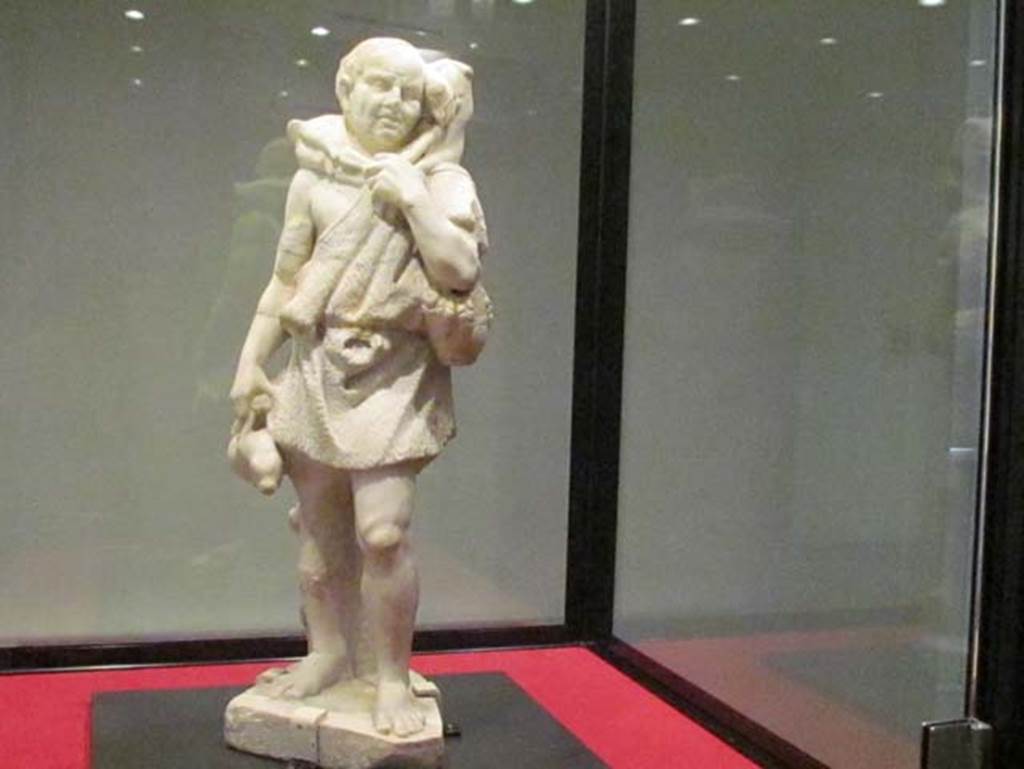 Stabiae, Villa del Pastore. Garden. Statue of a shepherd clothed in a rough skin, carrying a young goat on his shoulders.
He has a hare in his right hand, and slipped over his left arm, a basket filled with fruit and grain.
Photo courtesy of Donna Dollings.