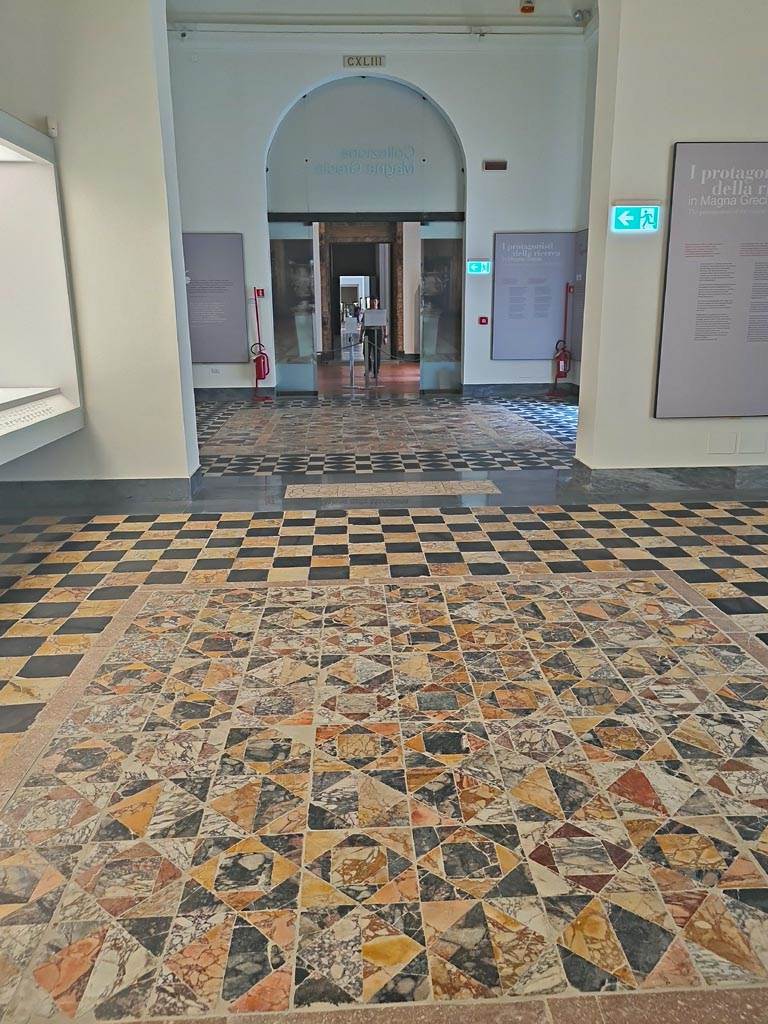 Mosaic in Naples Archaeological Museum, central mosaic panel from Room 13 of Secondo Complesso, Stabia.
July 2019. Looking from second room (CXLII) towards first room (CXLIII). Photo courtesy of Giuseppe Ciaramella.