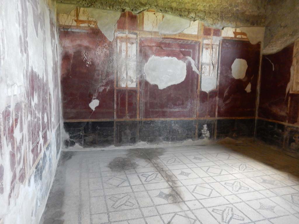 Stabiae, Villa Arianna, June 2019. Room 5 cubiculum, looking east from doorway. Photo courtesy of Buzz Ferebee.
According to the information card –
The floor of this cubiculum was decorated with a black and white reticulate geometric mosaic comprising squares alternating with shields; a few elements were detached in Bourbon times, which are now in the collections of the Naples National Archaeological Museum and also the British Museum in London.