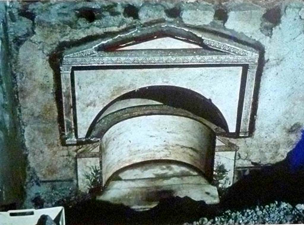 Boscoreale, Villa rustica in via Casone Grotta, proprietà Risi di Prisco. Lararium.
The pediment is supported by half-pilasters in stucco with framed leaf capitals decorated with plant motifs. 
The two angles of another pediment in plaster, visible below, belong to a previous niche of more reduced dimensions.
See Fergola, L., 1987. Comune di Boscoreale. Via Casone Grotta, proprietà Risi Di Prisco, in Rivista di Studi Pompeiani, 1, p. 164.