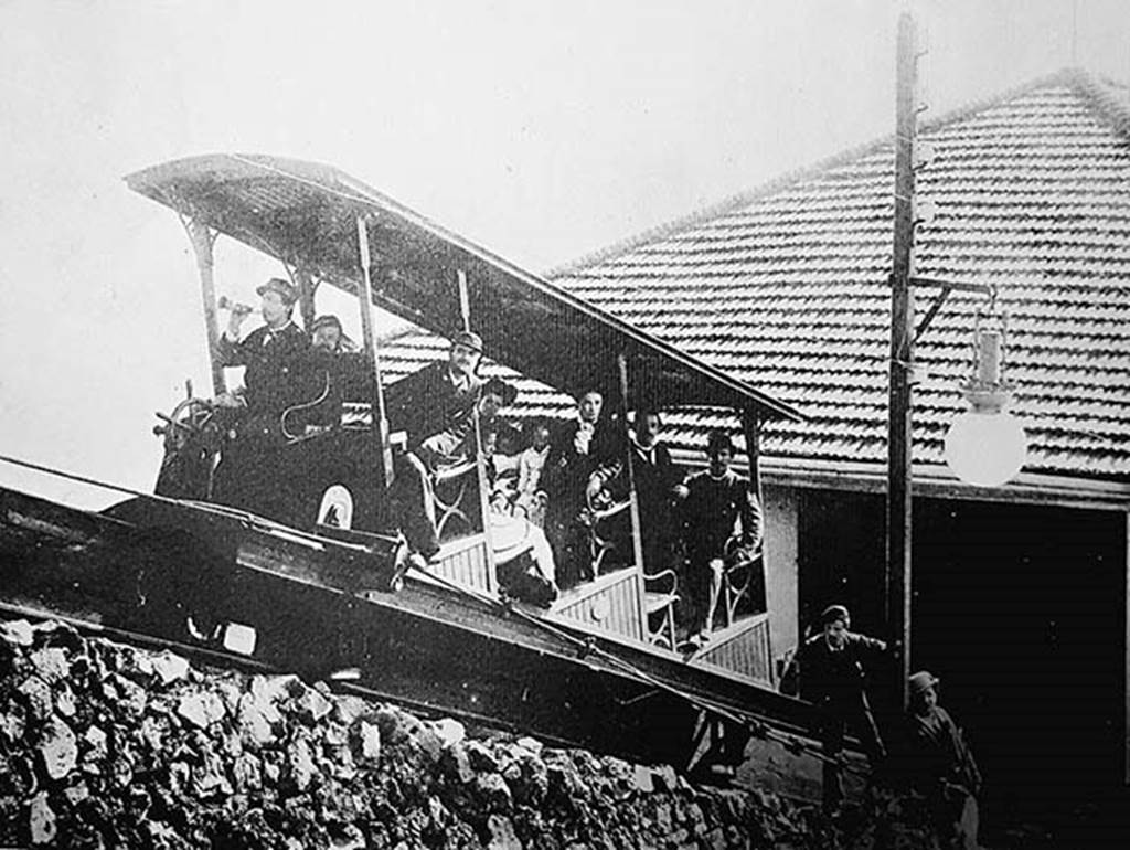 Vesuvius Funicular railway at the lower station c.1890.
Photo by Giorgio Sommer.
The winding house was at the bottom, where there were two 45 horsepower high pressure steam engines (one a reserve) and coal fired boilers. 
The winding drum had automatic brakes to control the speed and the cars also had automatic brakes applied if the cable went slack. 
As coal had to be brought up the mountain on horseback, this became an expensive item.