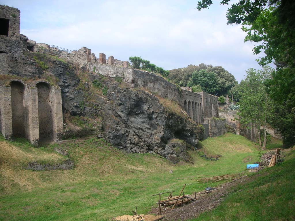 Rear of VIII.2.28, on left, and VIII.2.30 with city wall built on top of volcanic ledge, in centre. May 2011. 
Looking east along rear. Photo courtesy of Ivo van der Graaff.