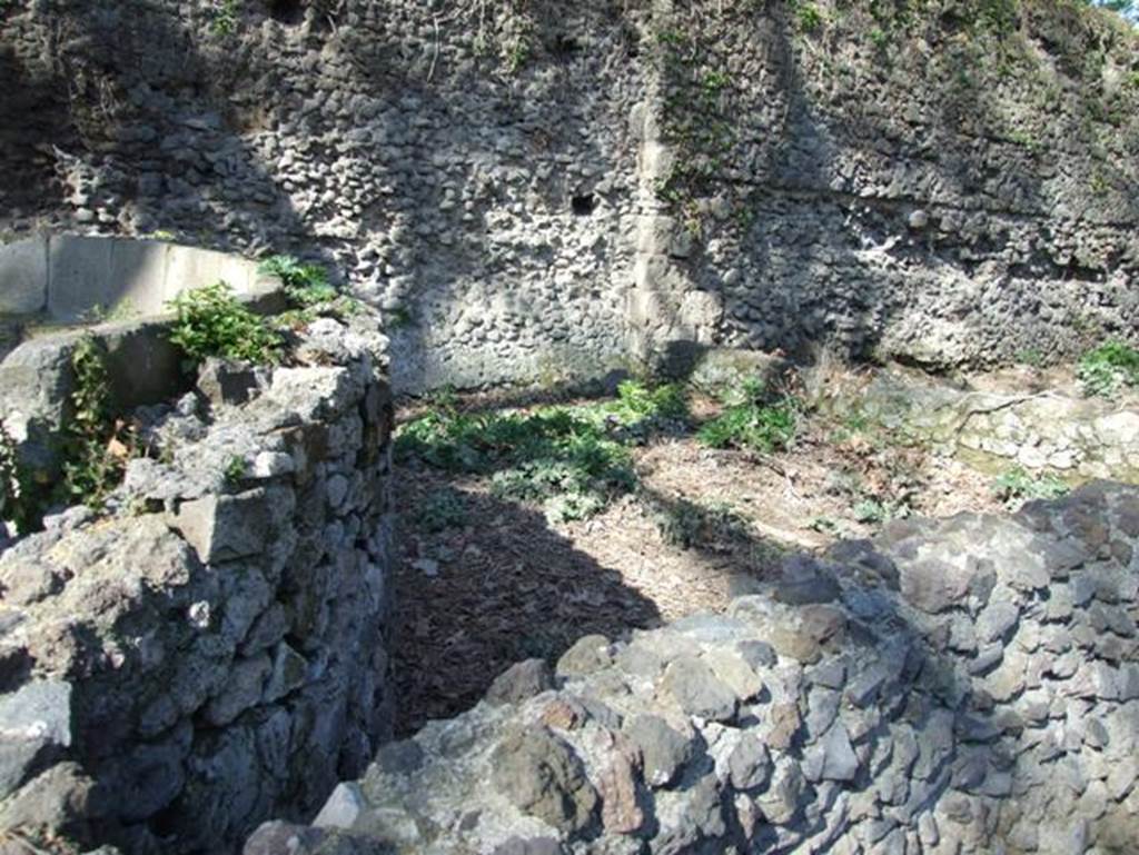 Porta Stabia, Pompeii. March 2009. 
Looking north at tomb of M Tullius, enclosure behind schola with Sarno travertine pier in city wall.
According to Van der Graaff –
“Two sections of opus incertum stretch on either side of the Porta Stabia………………….. 
To the east, the relic of an earlier internal Sarno travertine pier interrupts an otherwise uniform 60 metre stretch of opus incertum masonry.
The pier corresponds to a slight re-entrant in the curtain and the eastern enclosure wall of the schola tomb of Marcus Tullius.
The masonry adjacent to the gate is slightly rougher. It may represent a refurbishment or damage of the wall face associated with the tomb construction or a later partial collapse. At its foot, this section of the wall displays a well-finished surface that must have accommodated a lost plaster veneer. East of the pier, the masonry includes clear horizontal construction seams that marks the sequential deposition of the concrete during the construction process”.
See Van der Graaff, I. (2018). The Fortifications of Pompeii and Ancient Italy. Routledge, (p.115, and Note 24 and 25).